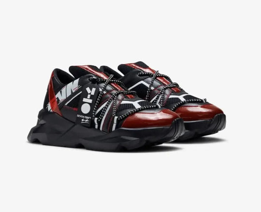 Three black, red, and brown sneakers on a white background