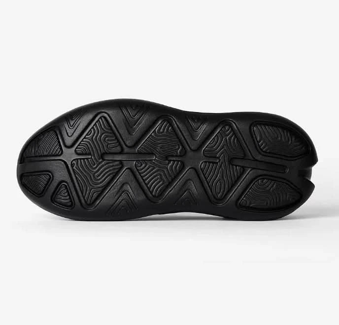 Black shoe sole with unique tread pattern on a white background