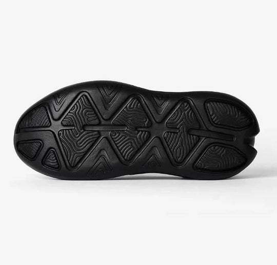 Black shoe sole with unique tread pattern on a white background