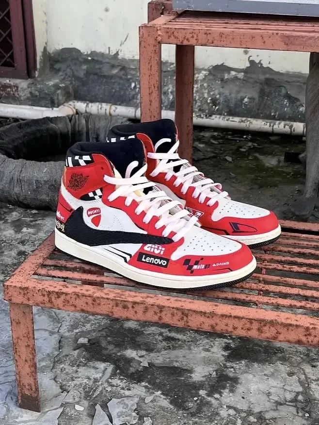 Red, white, and black sneakers on a rusted metal surface with a gritty background.