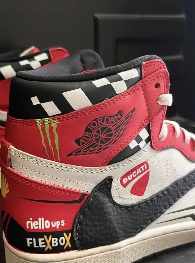 Red, black, and white sneakers with various brand logos on a dark background
