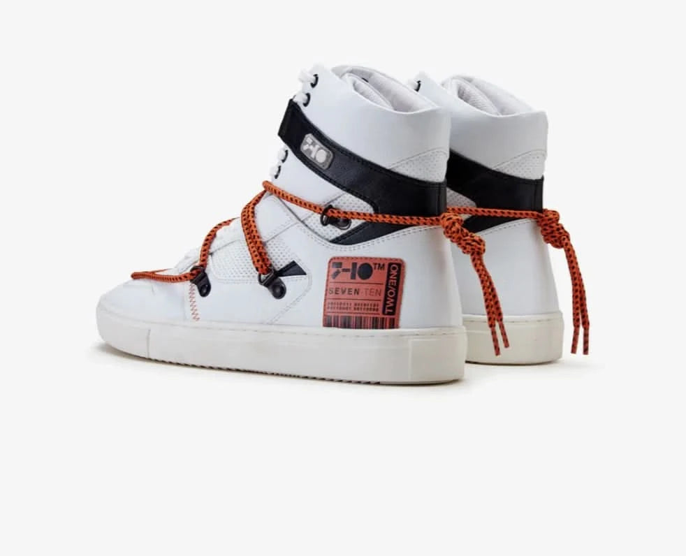White high-top sneakers with orange shoelaces on a white background
